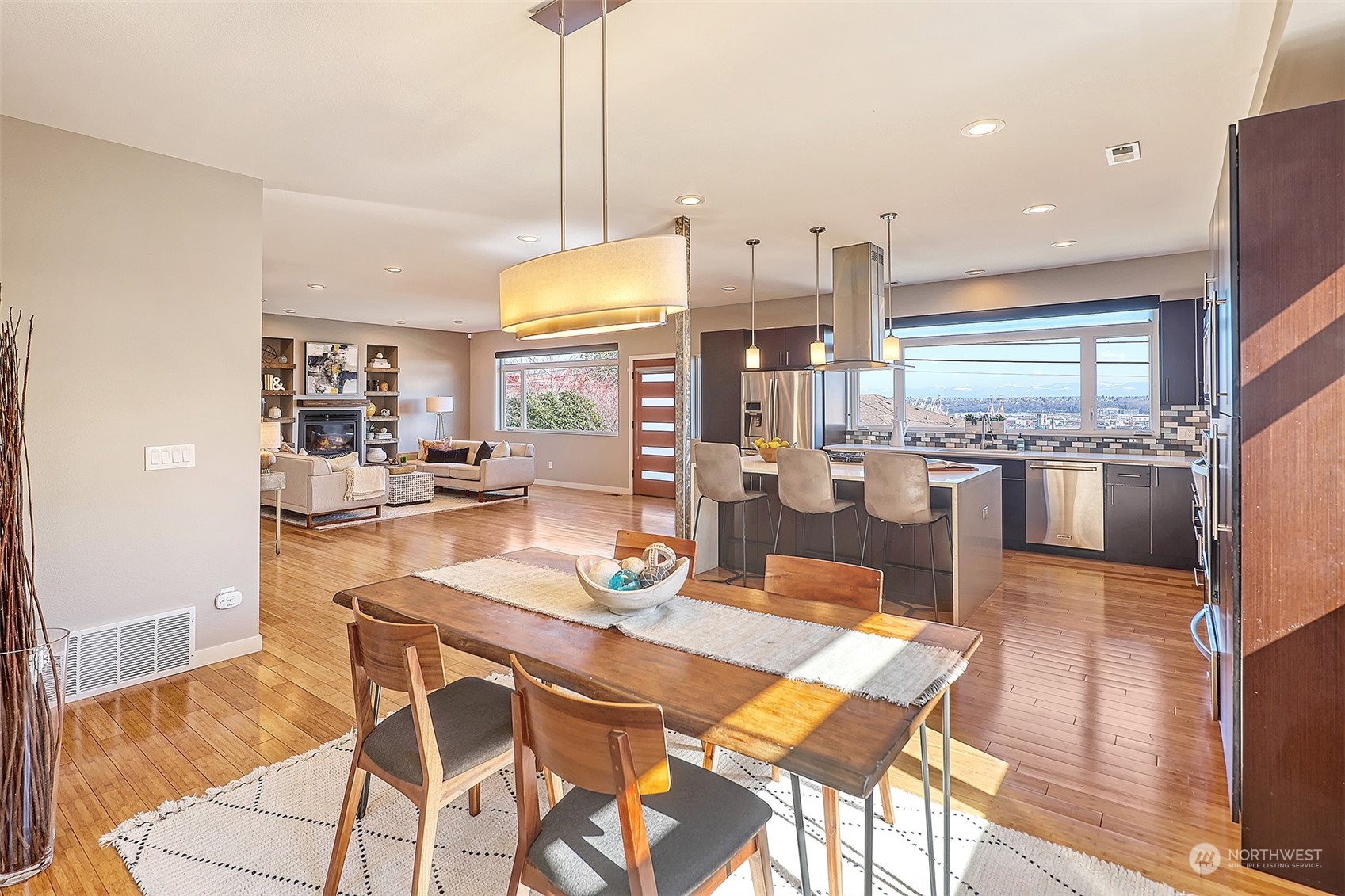 3263 35th Avenue Southwest Seattle, WA 98126 - Photo 10 of 38 a kitchen with stainless steel appliances kitchen island granite countertop a table chairs and a view of living room