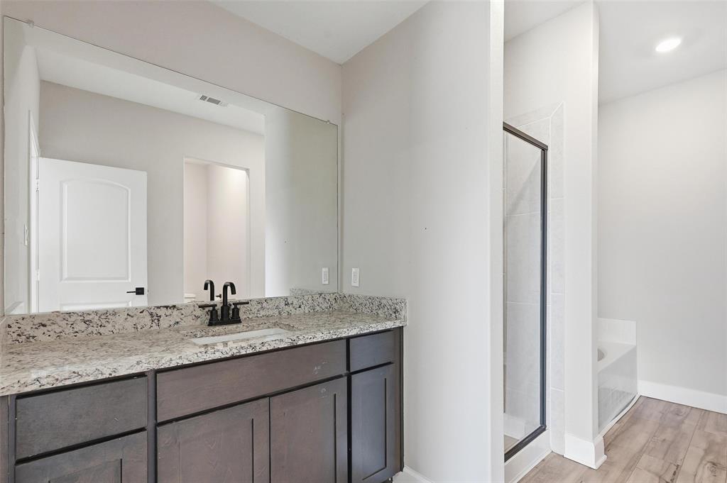 7612 Duck Bay Road Fort Worth, TX 76120 - Photo 11 of 32 a bathroom with a granite countertop sink and a mirror