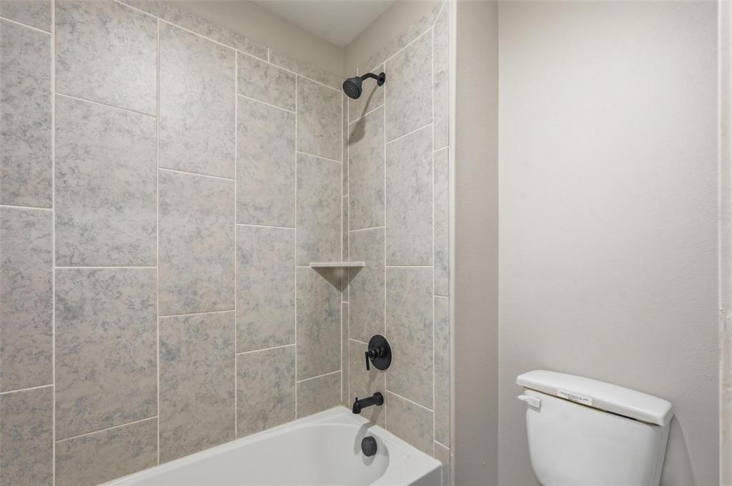 7612 Duck Bay Road Fort Worth, TX 76120 - Photo 19 of 32 a bathroom with a shower a toilet and a sink