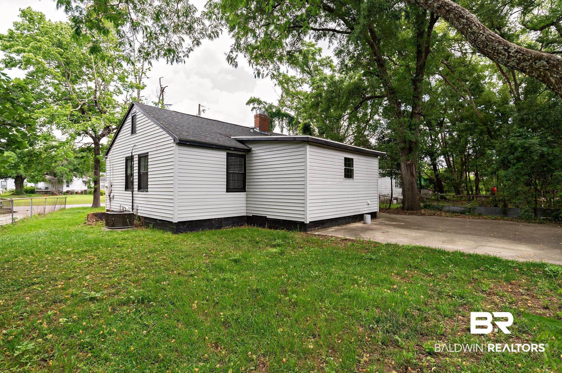 1869 Mott Drive West Mobile, AL 36617 - Photo 31 of 34 Exterior space featuring a patio area, a chimney, a front yard, and fence