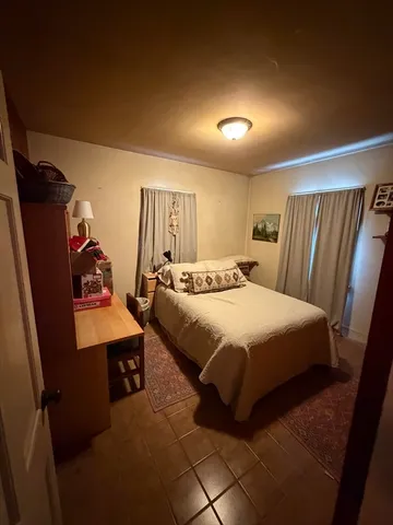 a bedroom with a bed next to a window