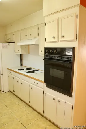 a kitchen with granite countertop white cabinets and appliances