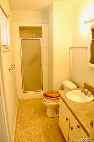 a bathroom with a granite countertop sink toilet and shower