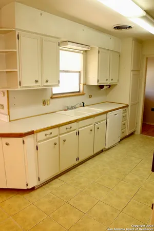a kitchen with cabinets appliances and a sink