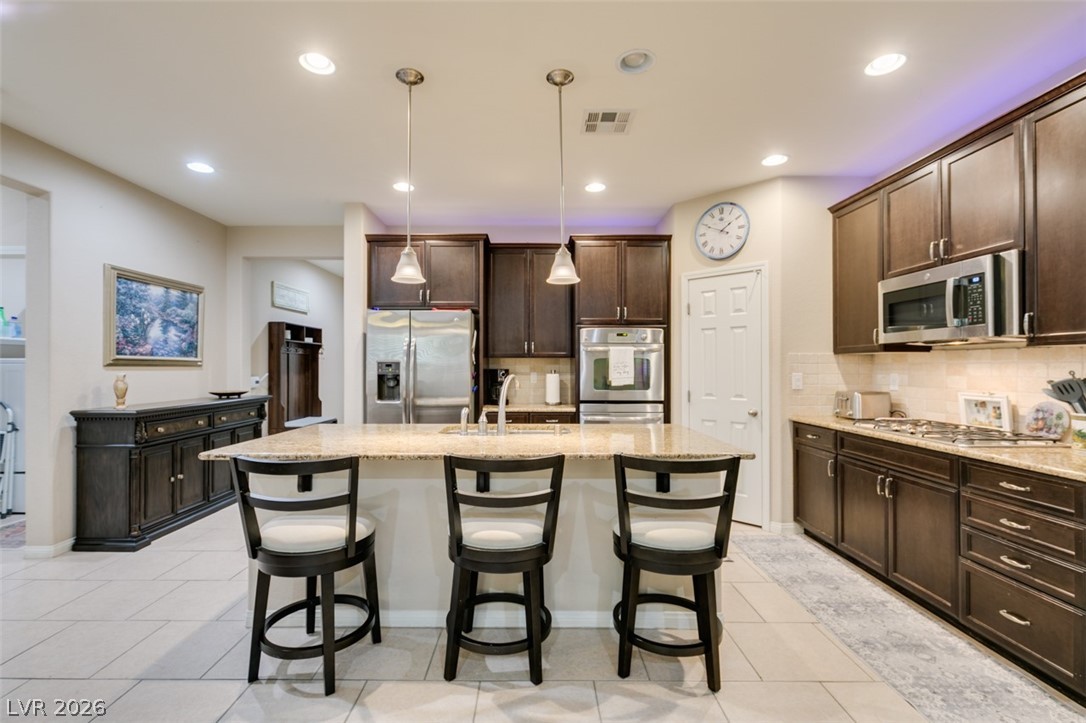 7375 Campbell Ranch Avenue Las Vegas, NV 89179 - Photo 11 of 45 Culinary delights await in this contemporary kitchen, boasting granite countertops and stainless steel appliances.