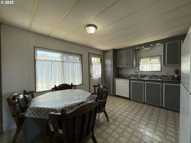 a kitchen with a stove a refrigerator and a dining table