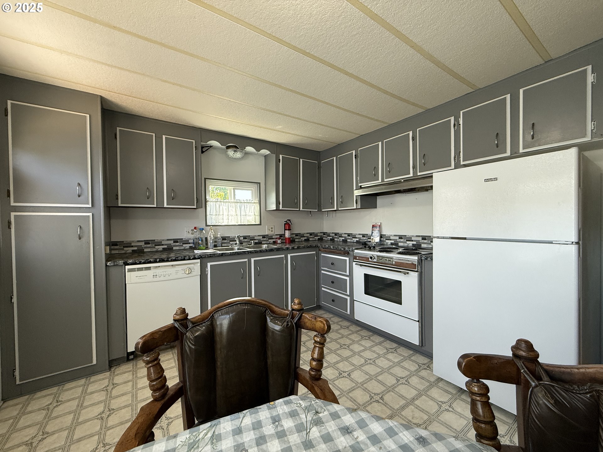 98620 Camellia Drive Brookings, OR 97415 - Photo 10 of 26 a kitchen with granite countertop a refrigerator stove and sink