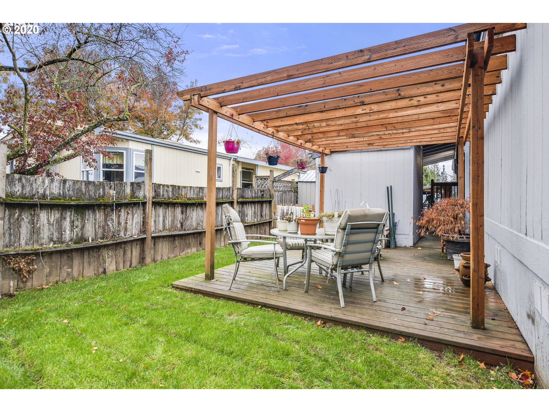 1500 South Sandoz Road, Unit 33 Newberg, OR 97132 - Photo 27 of 29 a view of a patio with table and chairs with wooden floor and fence