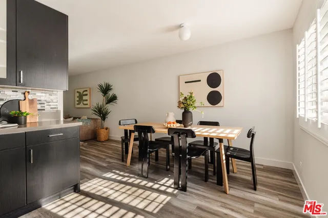 a dining room with chandelier fan and wooden floor