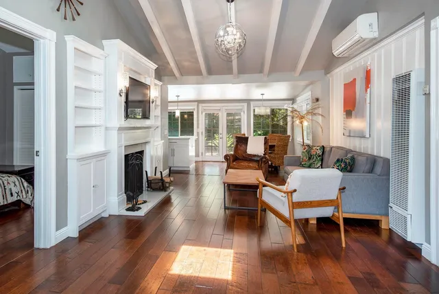 a living room with furniture fireplace and wooden floor