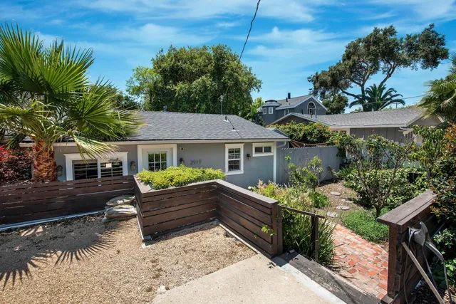 a front view of house with yard outdoor seating and covered with trees