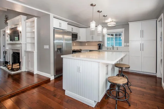 a kitchen with stainless steel appliances granite countertop a sink a stove and a refrigerator