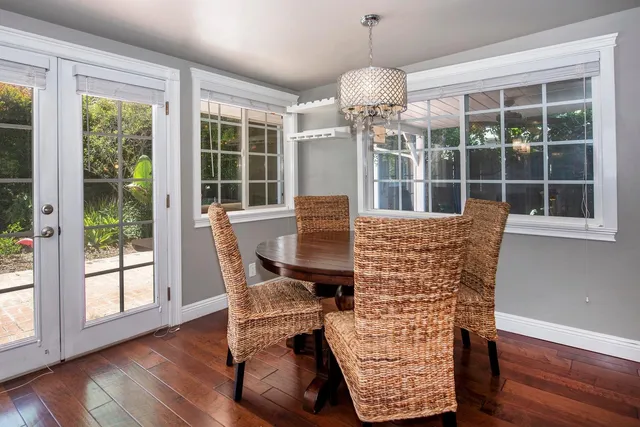 a dining room with furniture window and wooden floor