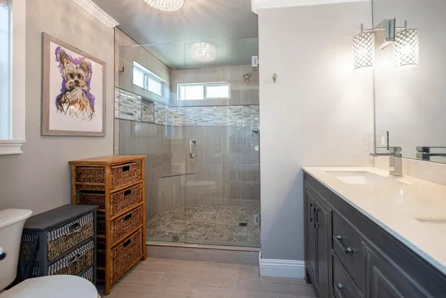 a bathroom with a granite countertop sink a mirror a vanity and a shower