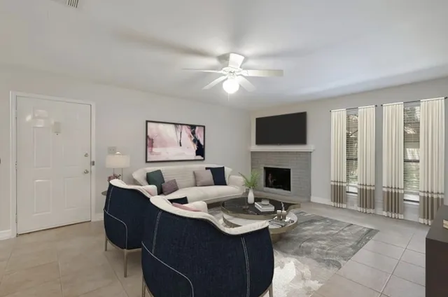 a living room with furniture a fireplace and a flat screen tv