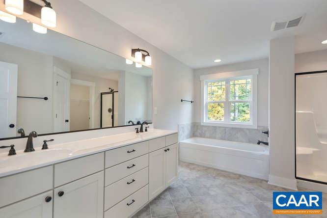 128 Wexford Ridge Road Ruckersville, VA 22968 - Photo 18 of 19 a spacious bathroom with a tub sink and mirror
