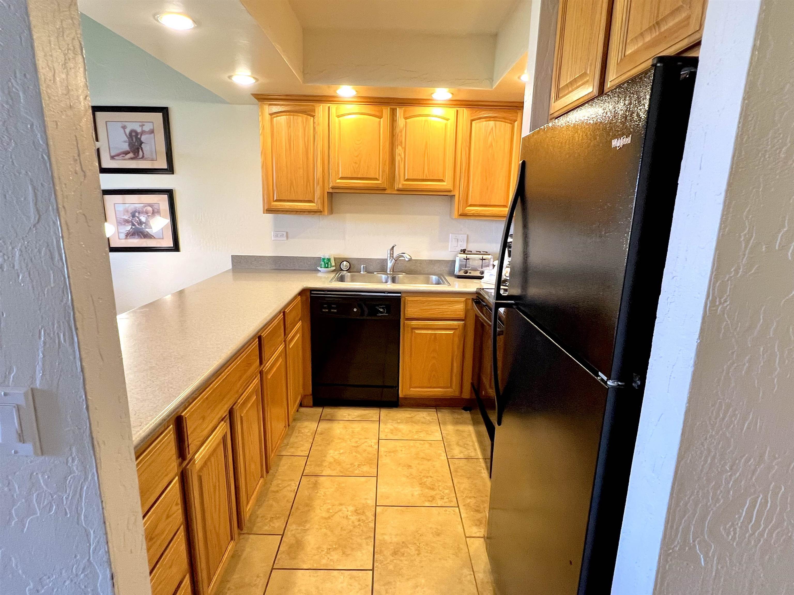 3543 Lower Honoapiilani Road, Unit J403 Lahaina, HI 96761 - Photo 9 of 23 a kitchen with stainless steel appliances granite countertop a refrigerator a sink and dishwasher