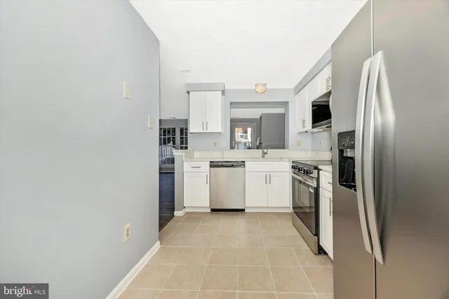 a kitchen with a sink a refrigerator and cabinets