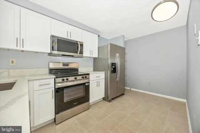 a kitchen with stainless steel appliances a stove microwave and a sink