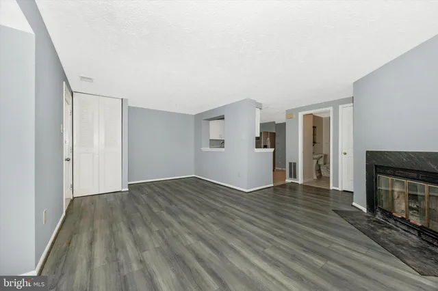 a view of empty room with wooden floor and fireplace