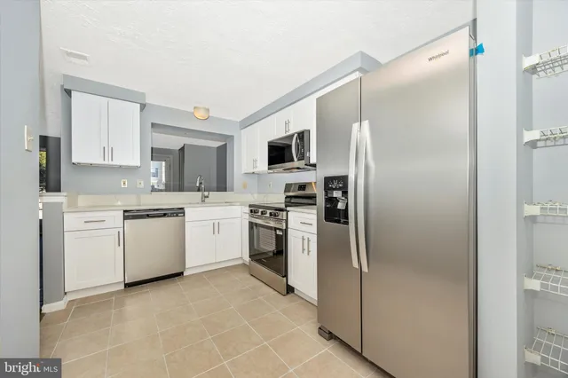 a kitchen with a sink stainless steel appliances and cabinets