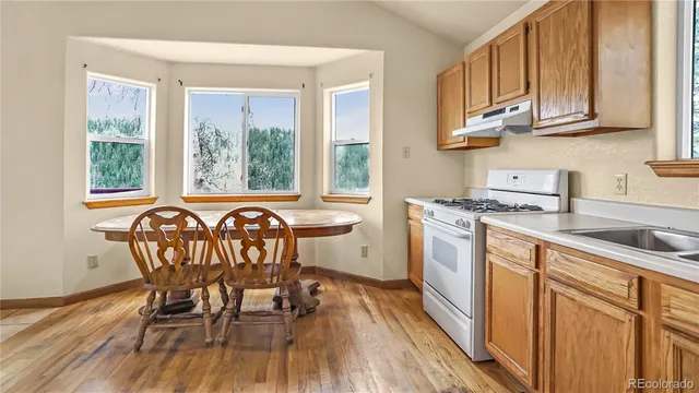 a kitchen with a table chairs sink and cabinets