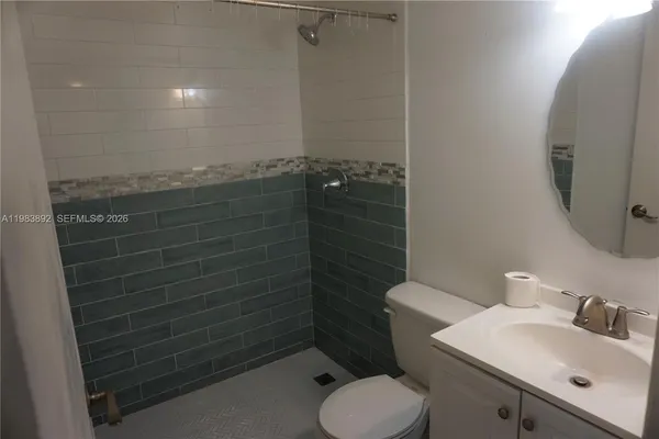 a bathroom with a toilet a sink and mirror