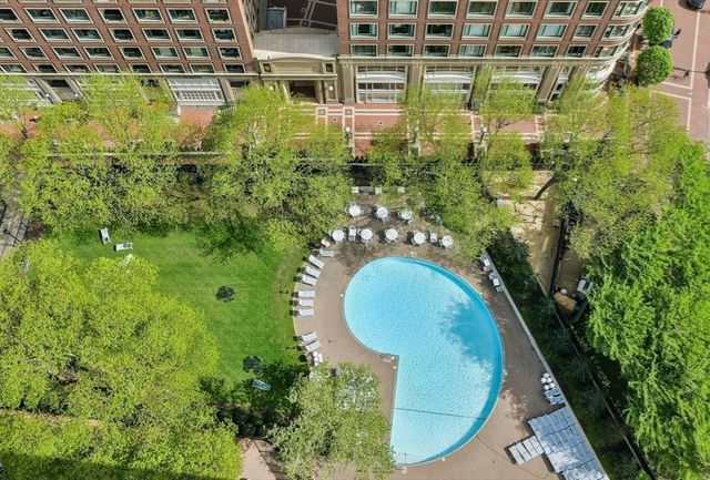 a view of a multi story residential apartment building with a yard and potted plants