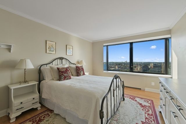 a bedroom with a bed and a dresser next to a window
