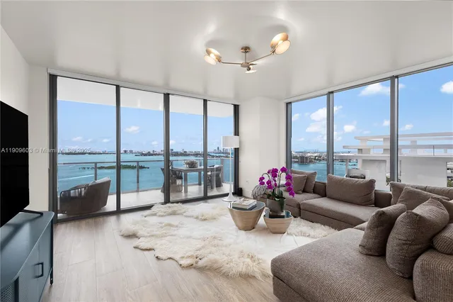 a living room with furniture and floor to ceiling windows