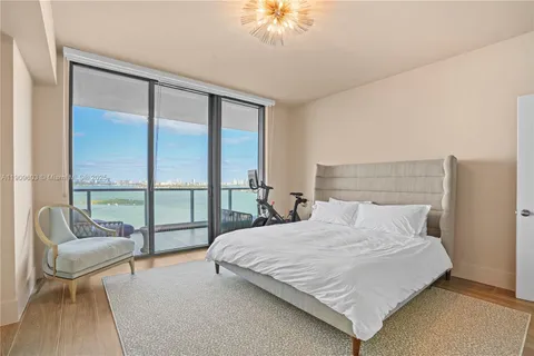 a bedroom with a bed and a large window