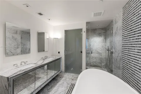 a bathroom with a tub sink shower and mirror
