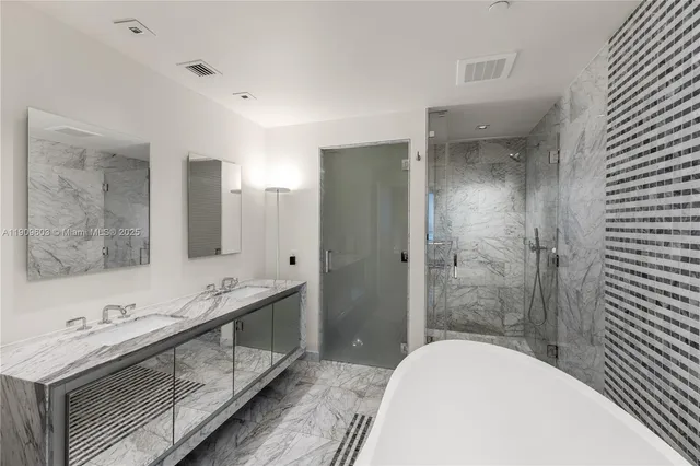 a bathroom with a tub sink shower and mirror