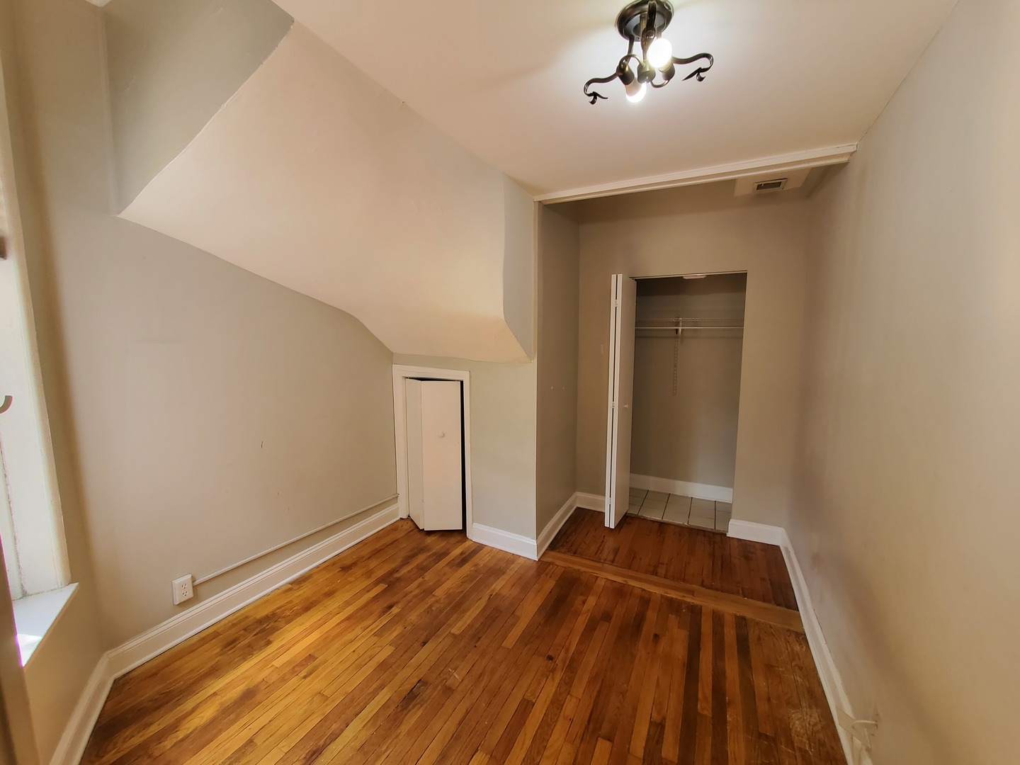 665 West Roscoe Street, Unit 1 Chicago, IL 60657 - Photo 8 of 10 a view of a room with wooden floor and a ceiling fan