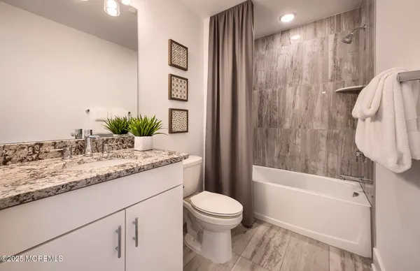 a bathroom with a granite countertop sink toilet and shower
