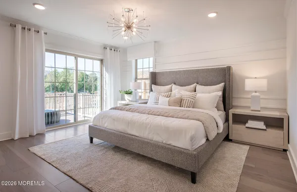 a spacious bedroom with a large bed and a chandelier