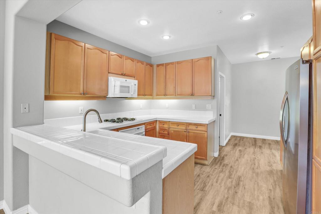 2318 Fallbrook Place Escondido, CA 92027 - Photo 11 of 34 a kitchen with a sink a stove a refrigerator and a window