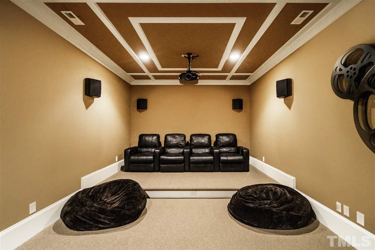 1512 Consett Court Raleigh, NC 27613 - Photo 22 of 30 Two-tiered theater room with reclining seats, projector, speakers, and screen