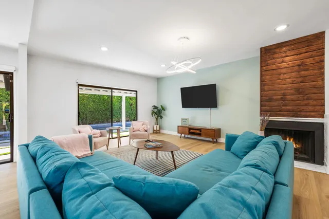 a living room with furniture kitchen view and a fireplace