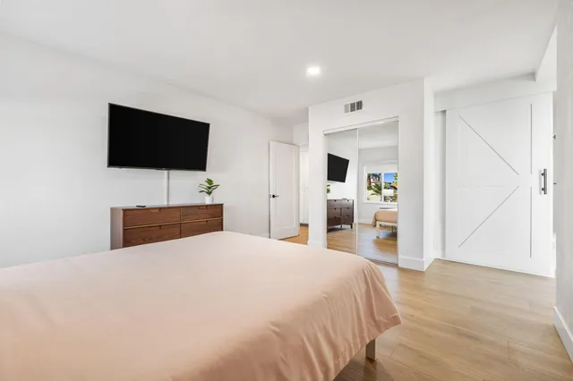 a hallway with a white cabinets and wooden floor