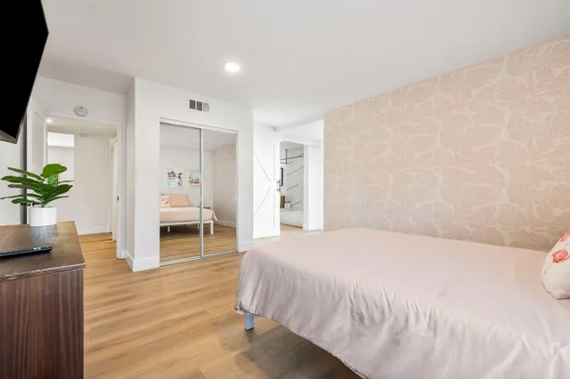 a bedroom with a bed and wooden floor