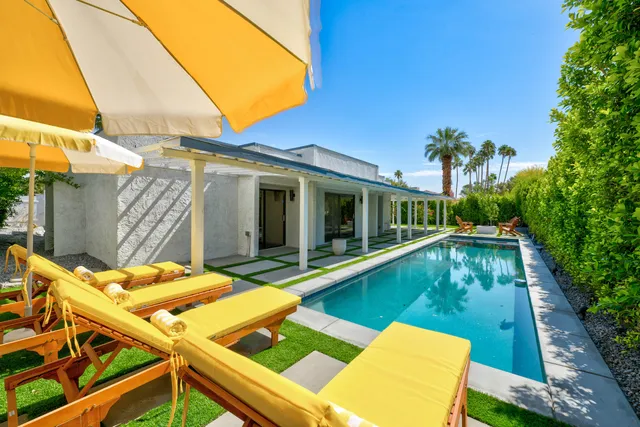 a view of a patio with lawn chairs next to a yard