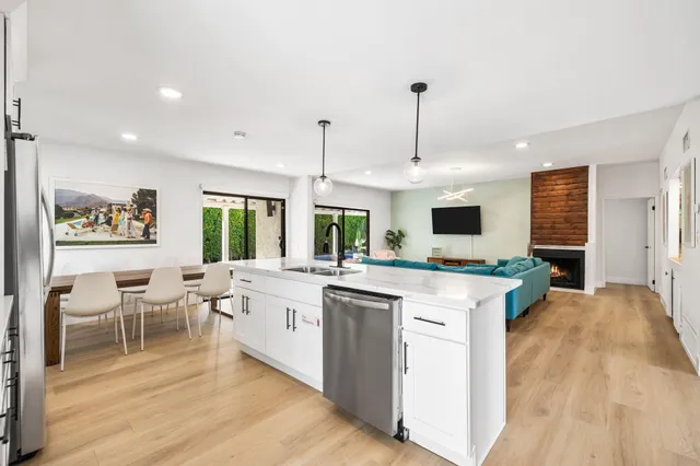 a kitchen with stainless steel appliances granite countertop sink stove and white cabinets