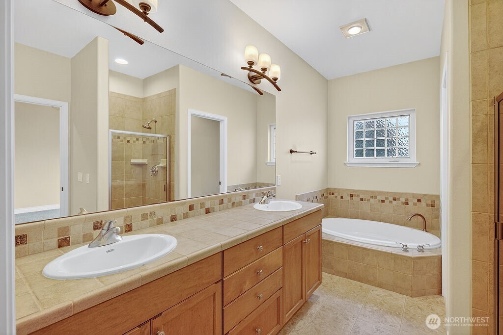 1845 Maple Street, Unit 26 Wenatchee, WA 98801 - Photo 28 of 40 a bathroom with a granite countertop tub a double vanity sink and a mirror