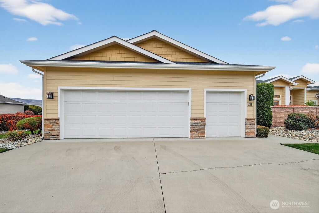 1845 Maple Street, Unit 26 Wenatchee, WA 98801 - Photo 9 of 40 a front view of a house with a yard and garage