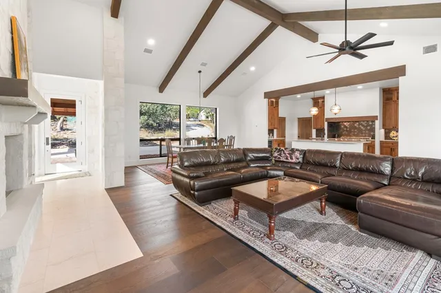 a living room with lots of furniture wooden floor and a chandelier