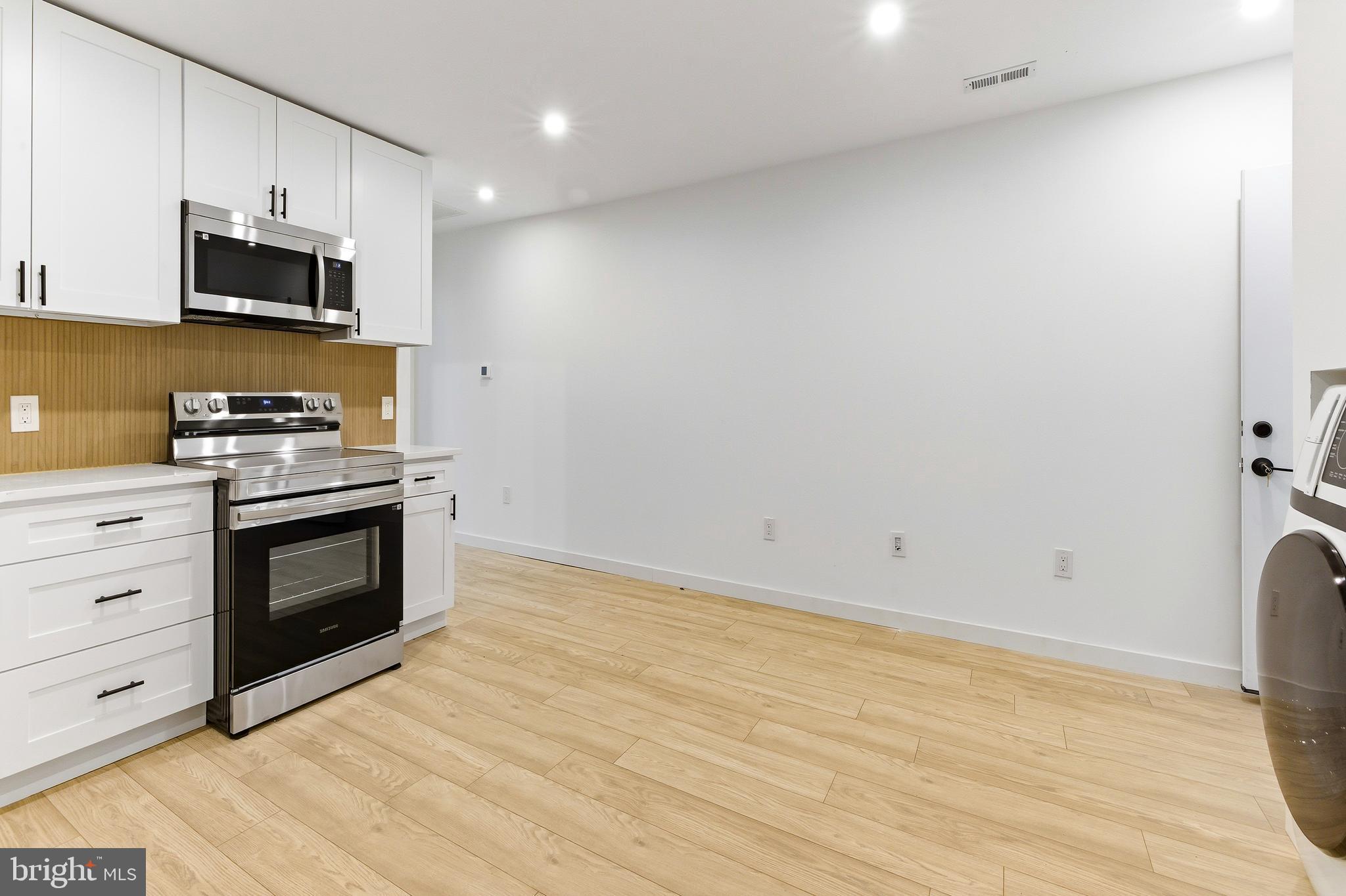 201 Broadway, Unit RES D Westville, NJ 08093 - Photo 8 of 11 a kitchen with stainless steel appliances a stove top oven microwave and cabinets