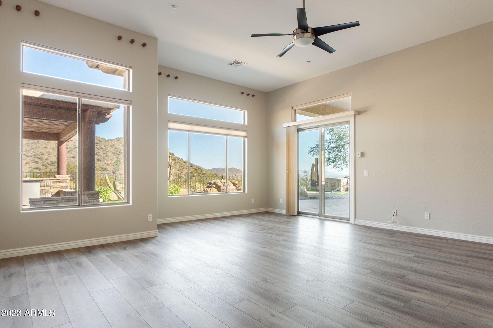 42409 North Back Creek Way Anthem, AZ 85086 - Photo 26 of 87 a view of an empty room with a window and wooden floor