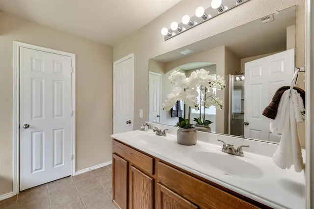a bathroom with a double vanity sink and a mirror