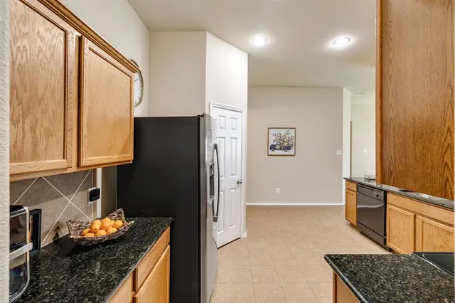 a kitchen with stainless steel appliances granite countertop a refrigerator and a stove